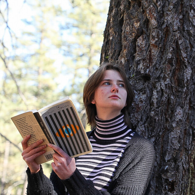 A student reading a book outside.